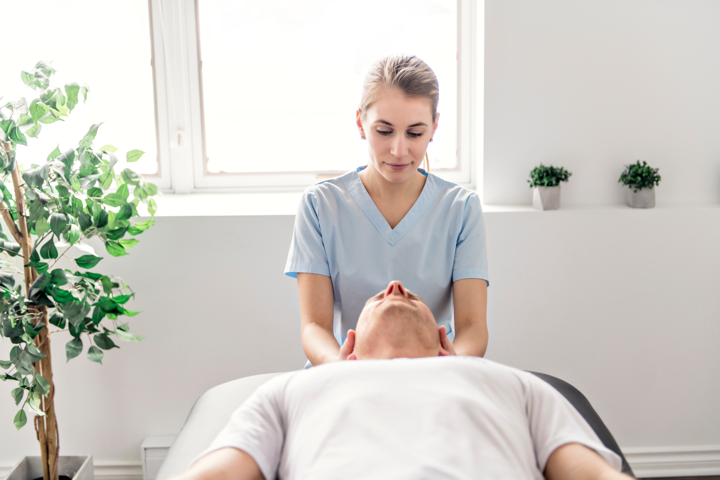 chiropractor looking at patient's neck