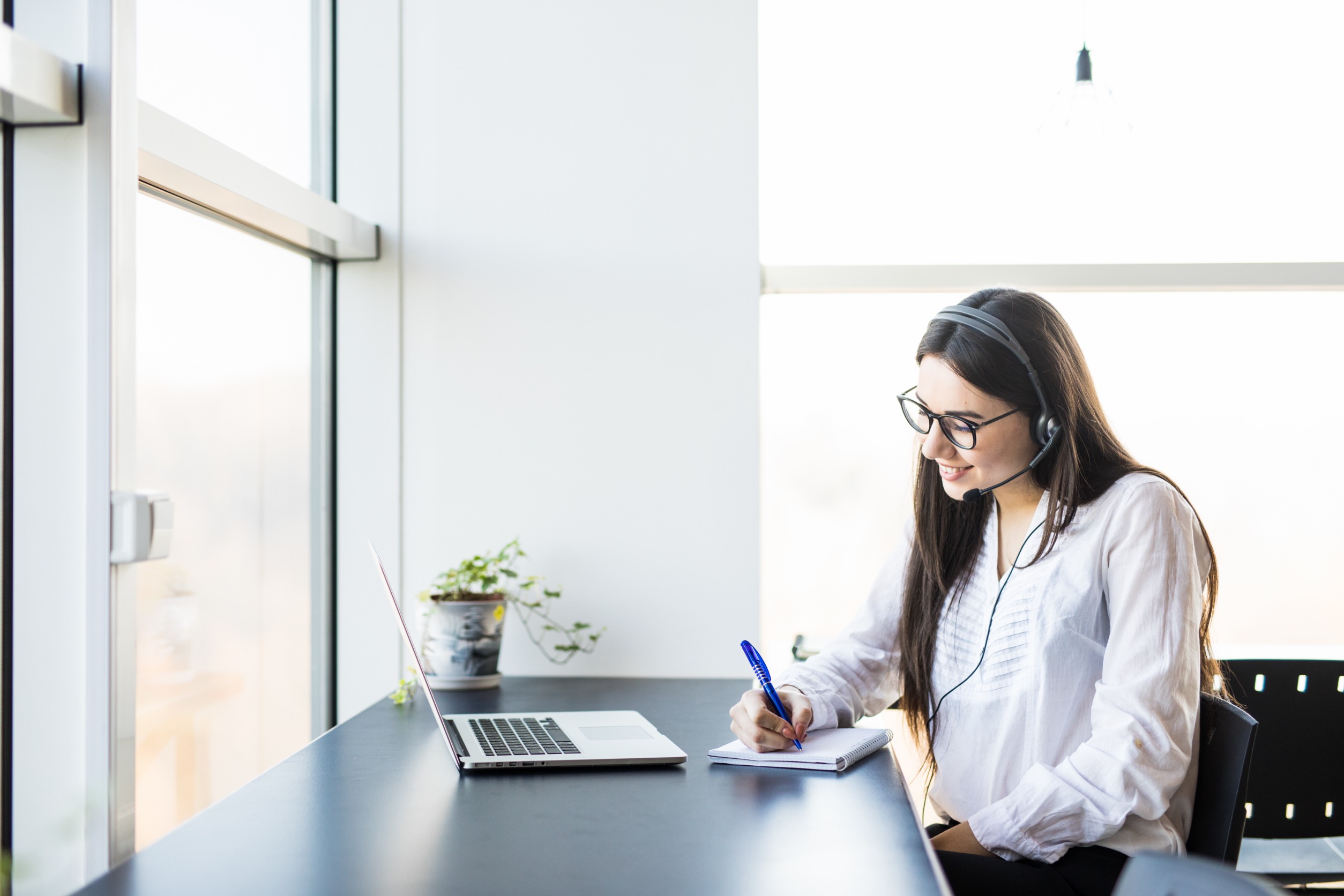 woman taking down appointment in office