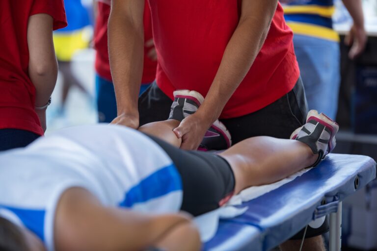 sports medicine proffessional working on athletes leg